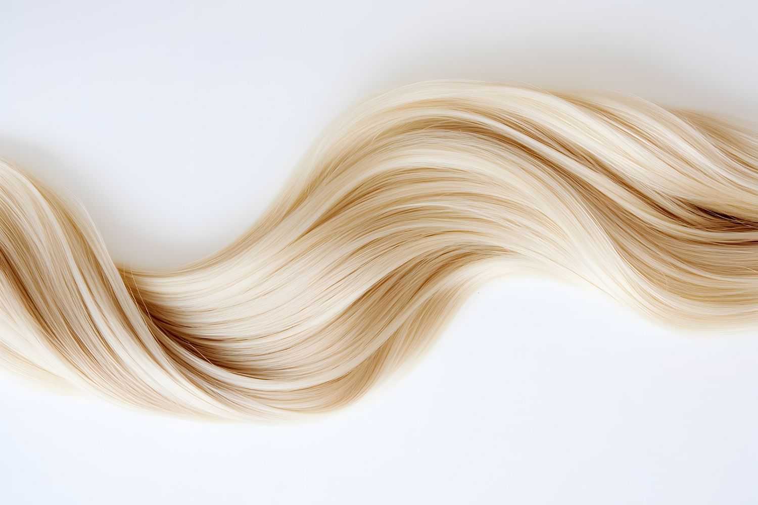 Flowing strands of smooth, silky blonde hair against a white background.